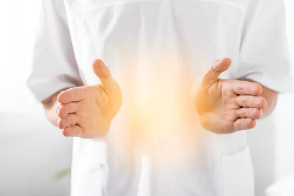 Cropped view of healer cleaning aura on white — Stock Photo