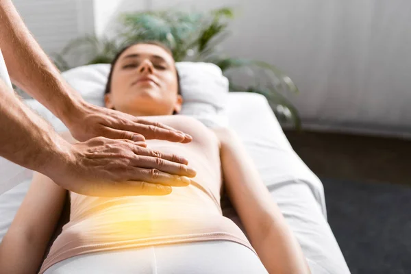 Vista ritagliata di guaritore in piedi vicino alla donna e tenendo le mani sopra il suo stomaco — Foto stock