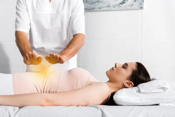 Cropped view of healer standing near woman and holding hands above her stomach — Stock Photo