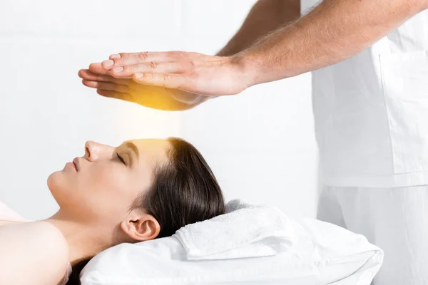 Cropped view of healer standing near woman and holding hands above her head — Stock Photo