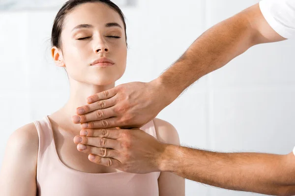 Frau sitzt mit geschlossenen Augen, während Heiler ihre Aura reinigt — Stockfoto