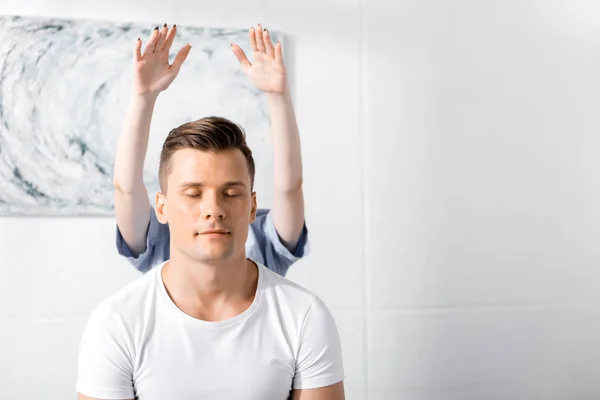 Front view of man sitting with closed eyes while healer cleaning his aura — Stock Photo