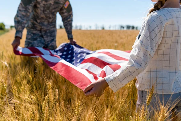 Fuoco selettivo del capretto e dell'uomo militare che tiene la bandiera americana — Stock Photo