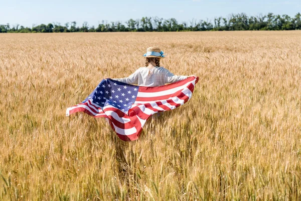 Rückseite des Kindes mit Strohhut mit amerikanischer Flagge mit Sternen und Streifen im goldenen Feld — Stockfoto