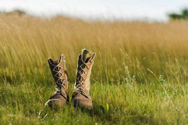 Enfoque selectivo de botas militares en hierba verde - foto de stock