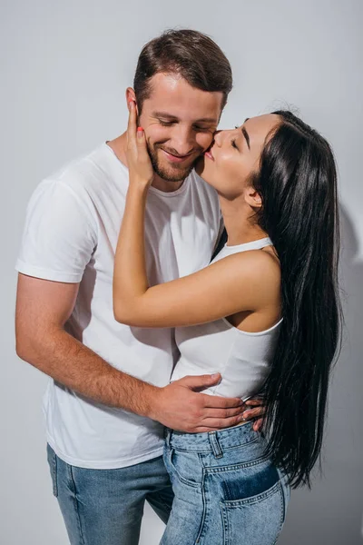 Feliz joven hombre y chica abrazos y besos con los ojos cerrados - foto de stock