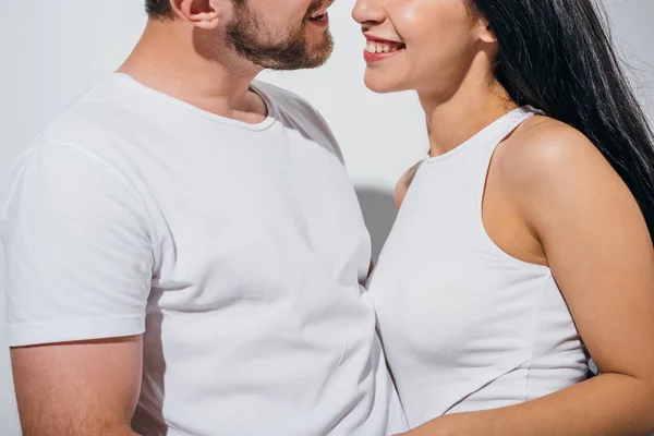 Recortado vista de pareja en el amor sonriendo mientras de pie cerca de uno al otro - foto de stock