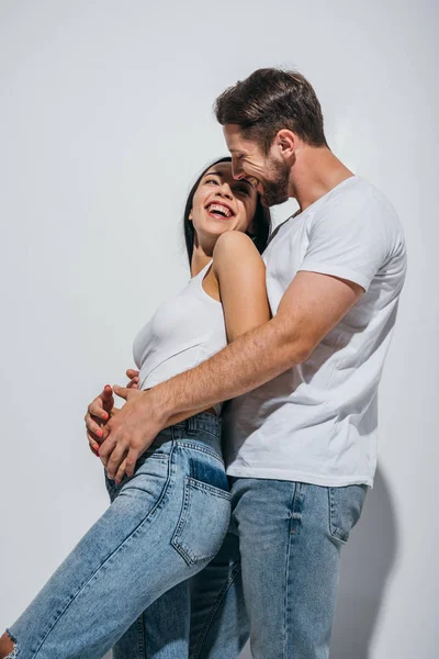 Giovane uomo in piedi dietro la fidanzata e abbracciarla mentre si guarda l'un l'altro — Foto stock