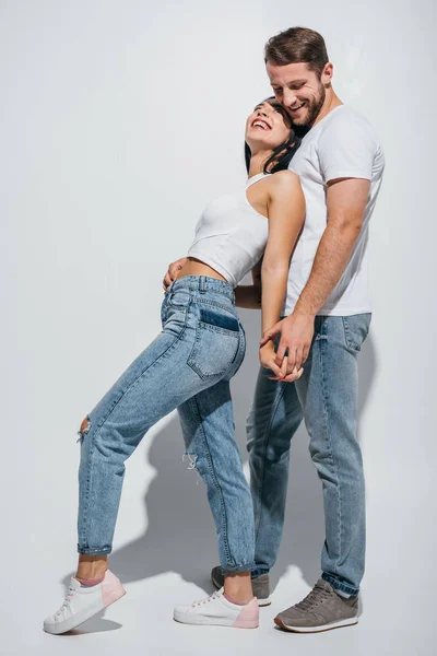 Full length view of young couple standing close to each other and holding hands — Stock Photo