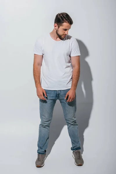 Full length view of handsome young man standing and looking away — Stock Photo