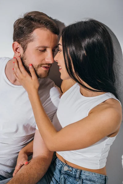 Jeune couple amoureux assis sur le sol, souriant et essayant de s'embrasser — Photo de stock