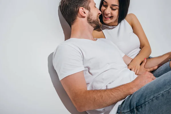 Joven pareja en el amor sonriendo mientras se sienta cerca el uno del otro - foto de stock