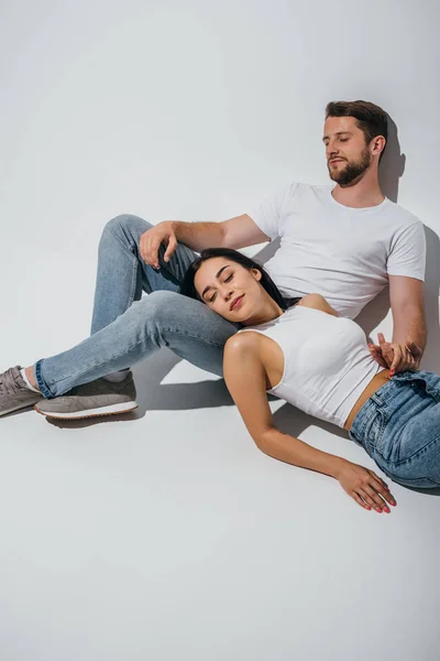 Beautiful girl lying on knees of boyfriend with closed eyes — Stock Photo