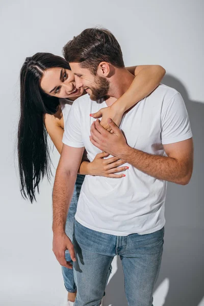 Belle fille câlin copain de dos, souriant et regardant gars — Photo de stock