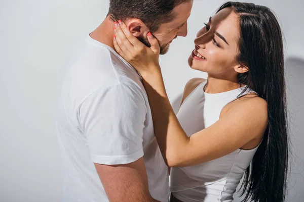 Pareja joven enamorada sonriendo y mirándose - foto de stock