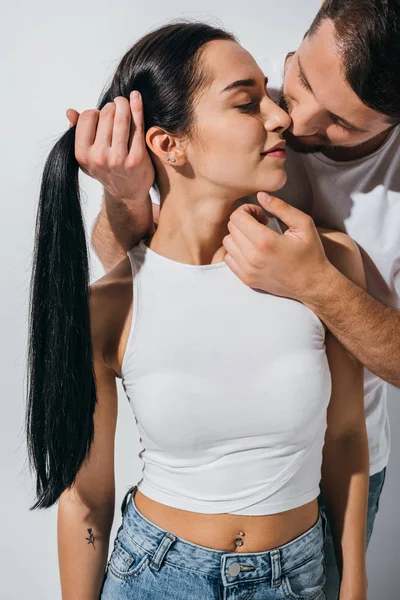 Guapo joven sosteniendo pelo de chica y tratando de besar novia - foto de stock