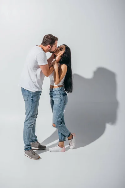 Vista completa de hombre joven y chica besándose con los ojos cerrados - foto de stock