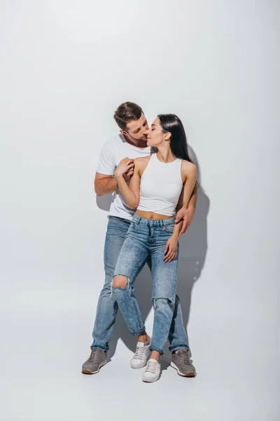 Pleine longueur vue de jeune homme étreignant petite amie de dos — Photo de stock