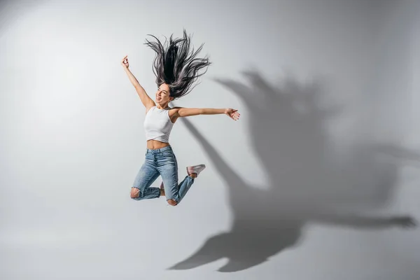 Full length view of excited girl jumping with hands in air — Stock Photo