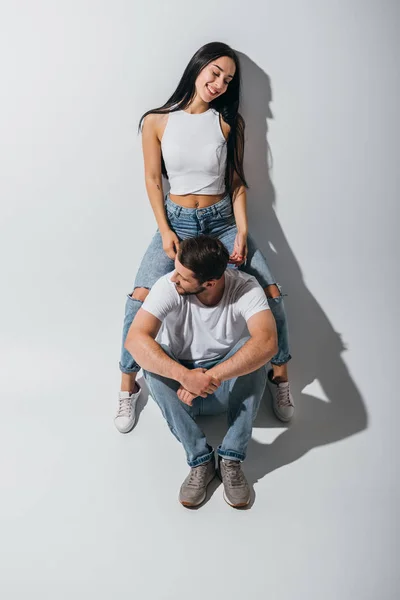 Full length view of girl sitting on shoulders of young man while guy looking away — Stock Photo