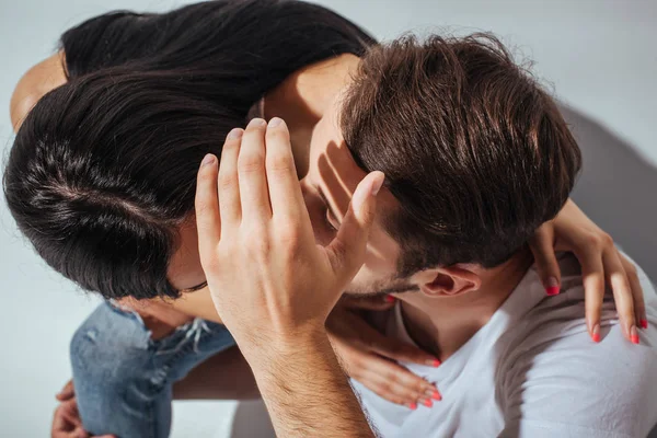 Vista superior do jovem casal beijando enquanto o homem escondendo rostos com a mão — Fotografia de Stock