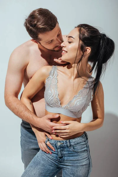 Beautiful girl smiling while young man hugging girl from back — Stock Photo