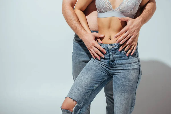 Corte vista de homem nu e muscular menina abraçando no branco — Fotografia de Stock