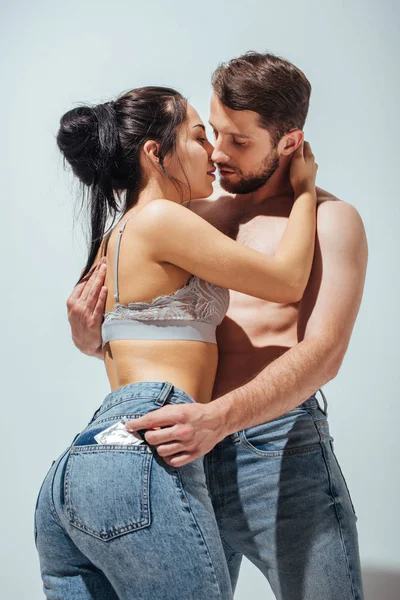 Sexy casal abraçando e tentando beijar enquanto o homem adiando preservativo de jeans de menina — Fotografia de Stock