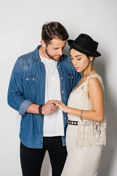 Young couple in stylish clothes standing close to each other and holding hands — Stock Photo