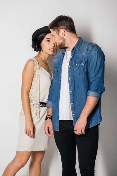 Two young people in fashionable clothes standing close and looking at each other — Stock Photo