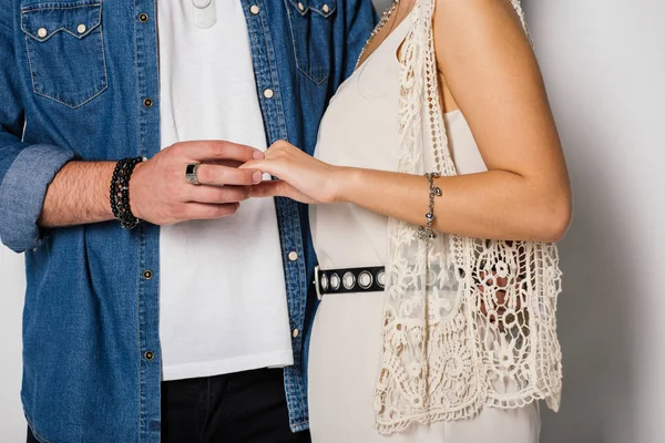 Vista recortada de la pareja joven en ropa elegante de pie cerca el uno del otro y cogidas de la mano - foto de stock