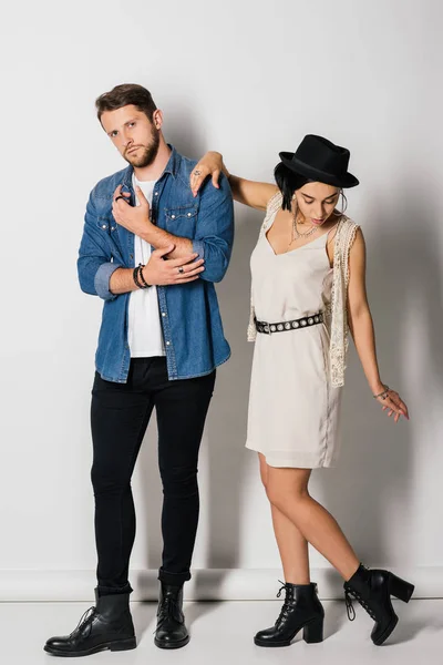 Full length view of stylish man looking at camera and girl looking on boots — Stock Photo