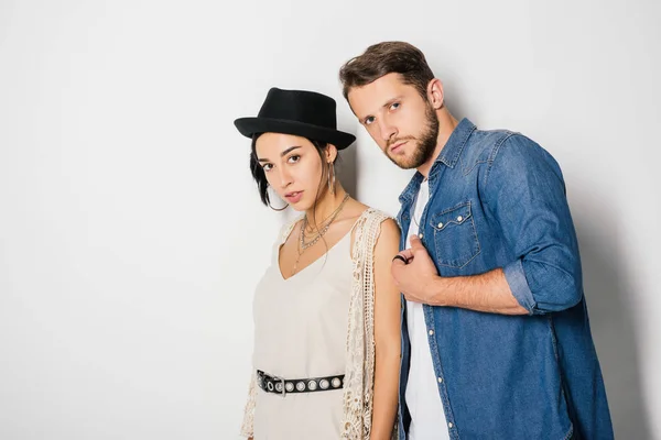 Handsome man and beautiful girl in fashionable clothes looking at camera on white — Stock Photo
