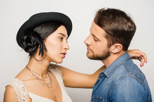 Casal bonito grave em roupas na moda olhando um para o outro no fundo branco — Fotografia de Stock