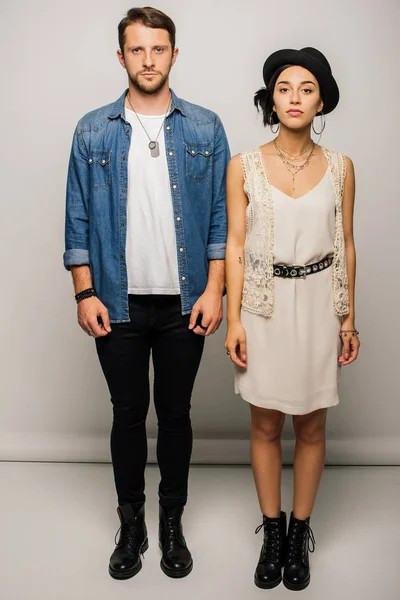 Full length view of stylish couple standing straight and looking at camera — Stock Photo