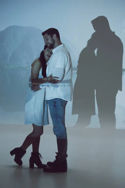 Full length view of coule standing in dark room and hugging each other — Stock Photo