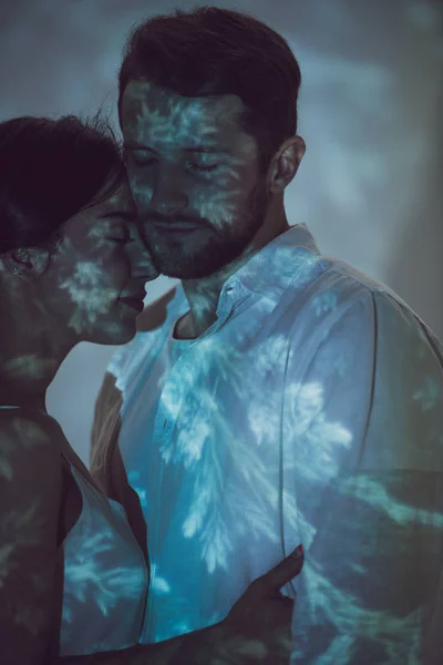 Zwei verliebte Menschen umarmen sich, während sie auf einem dunklen Platz stehen — Stockfoto