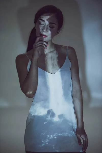 Красивая женщина, стоящая в темноте с закрытыми глазами в позе — стоковое фото