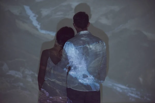 Back view of couple standing in dark room and hugging each other — Stock Photo