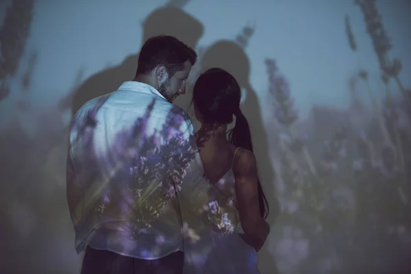 Vista posteriore di ragazza e uomo che si abbracciano e si guardano mentre stanno in piedi in un luogo buio — Foto stock