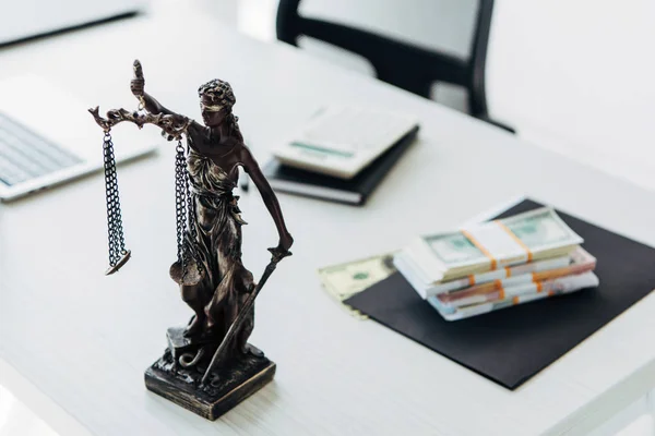 Foco seletivo de estatueta de justiça perto de dinheiro em mesa de madeira — Fotografia de Stock