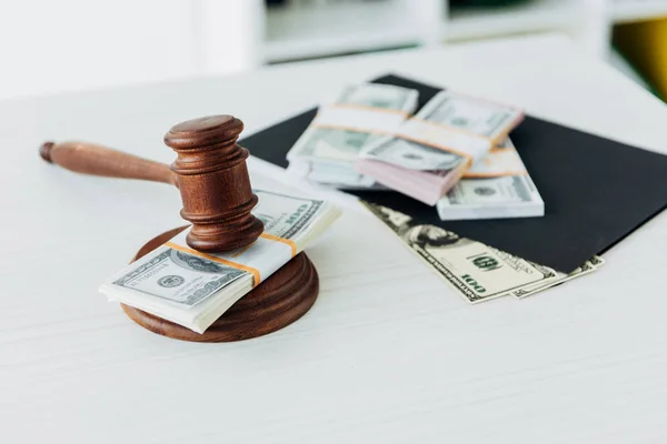 Selective focus of gavel of judge near dollar banknotes on table — Stock Photo