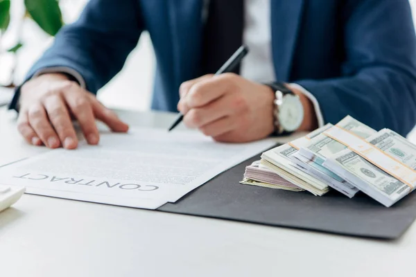 Selective focus of money near businessman signing contract in office — Stock Photo