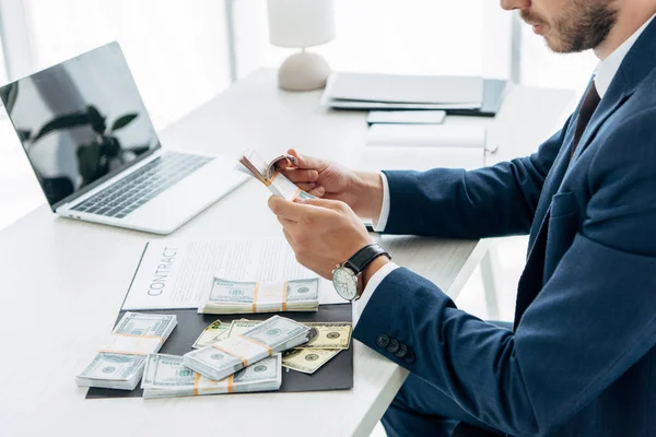 Cropped view of man holding bribe while sitting in office — Stock Photo