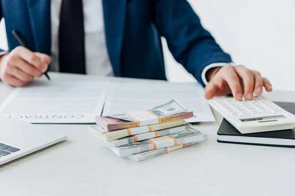 Cropped view of businessman using calculator near bribe and contract — Stock Photo