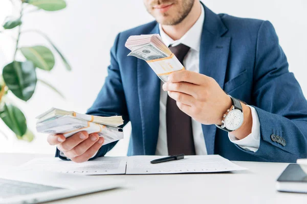 Selective focus of businessman holding dollar banknotes near contract — Stock Photo