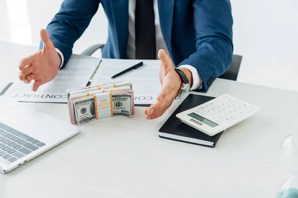 Vista recortada del hombre gesticulando cerca de billetes de dólar y contrato - foto de stock