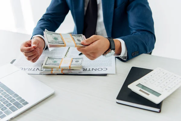 Vista recortada del hombre de negocios en billetes de dólar de desgaste formal cerca del contrato - foto de stock