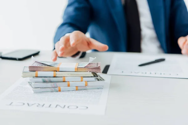 Vista recortada de hombre de negocios en el gesto de desgaste formal cerca de billetes de dólar - foto de stock