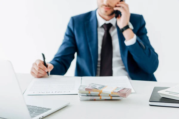Selective focus of bribe near man talking on smartphone in office — Stock Photo
